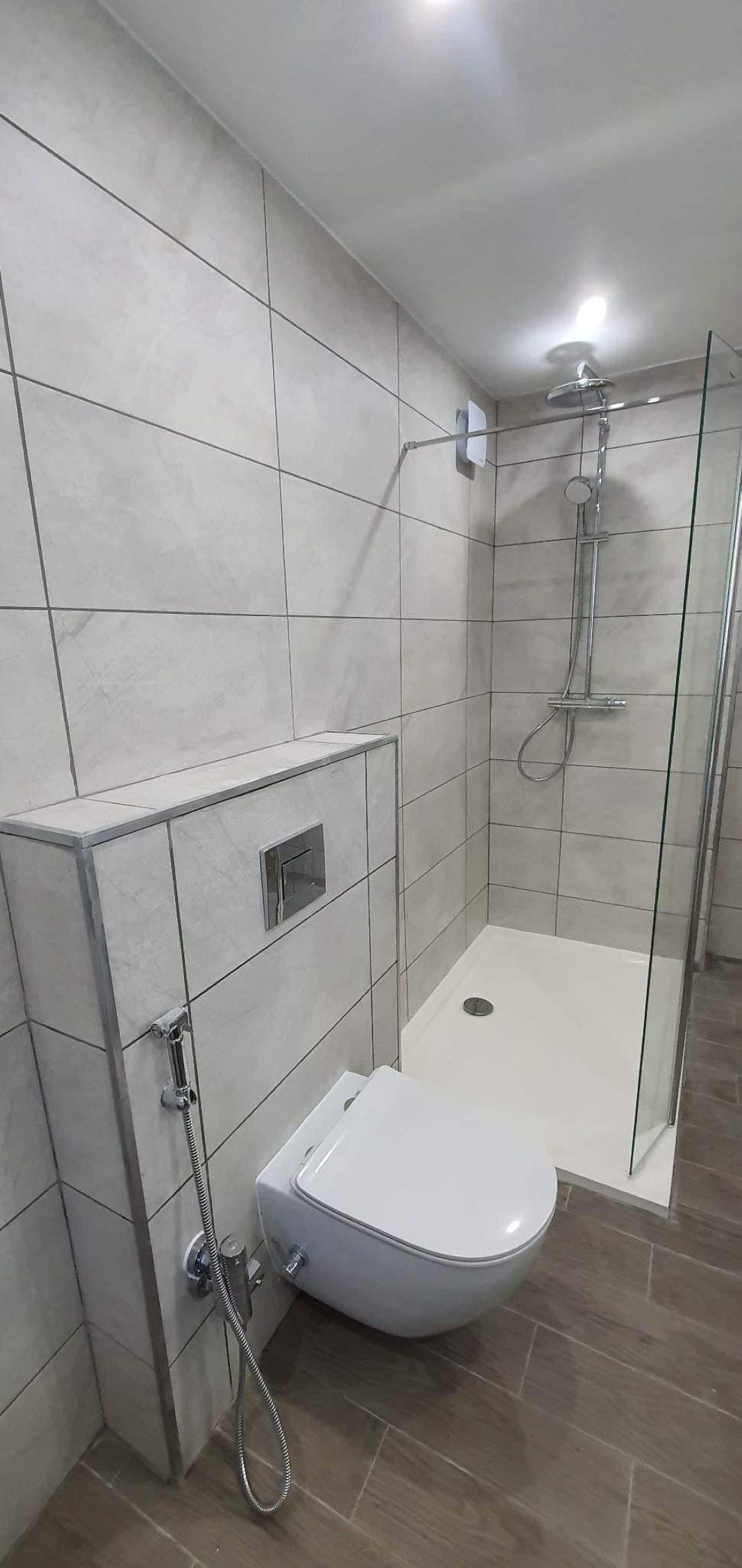 Compact Bathroom Makeover with Wall-Mounted Toilet and Rain Shower