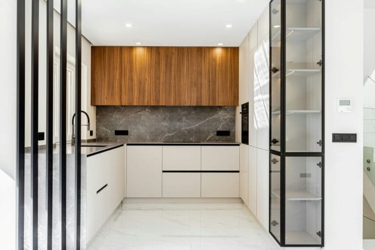 Luxury Kitchen with Glass Partition, White Cabinets, and Stone Countertops