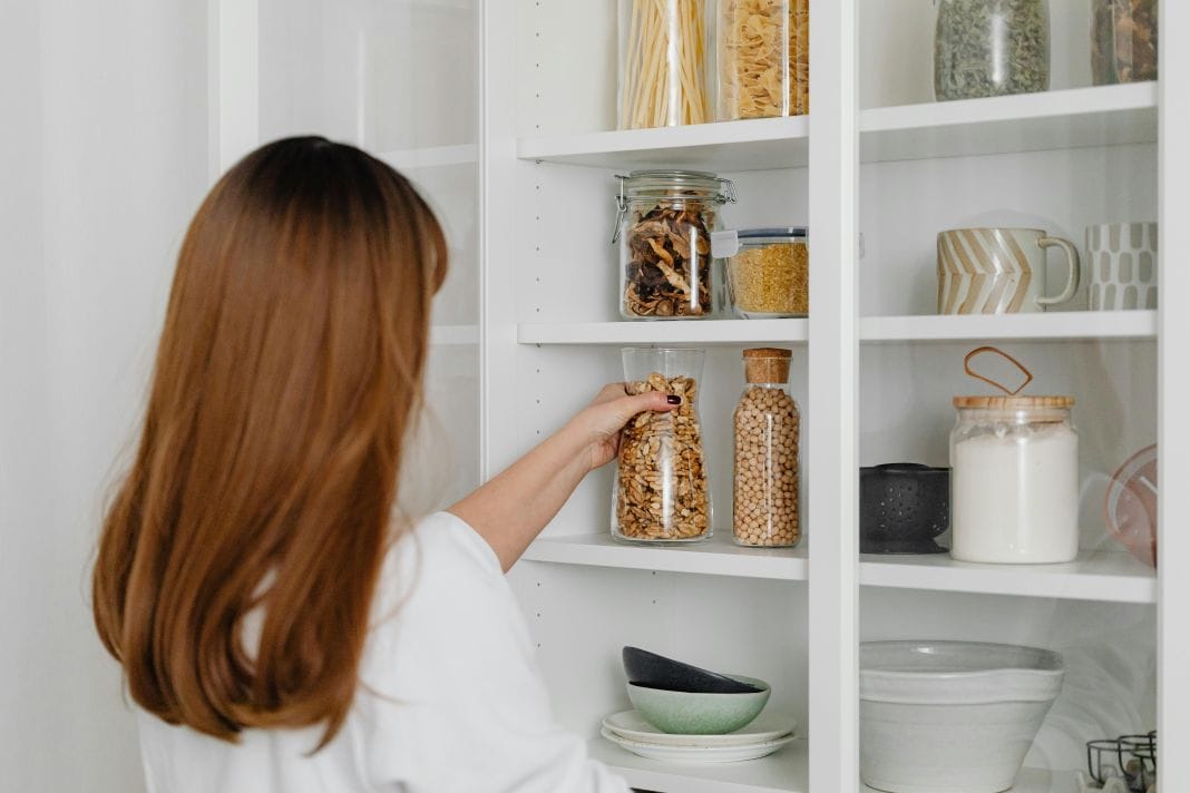 a homeowner using a kitchen with built in storage
